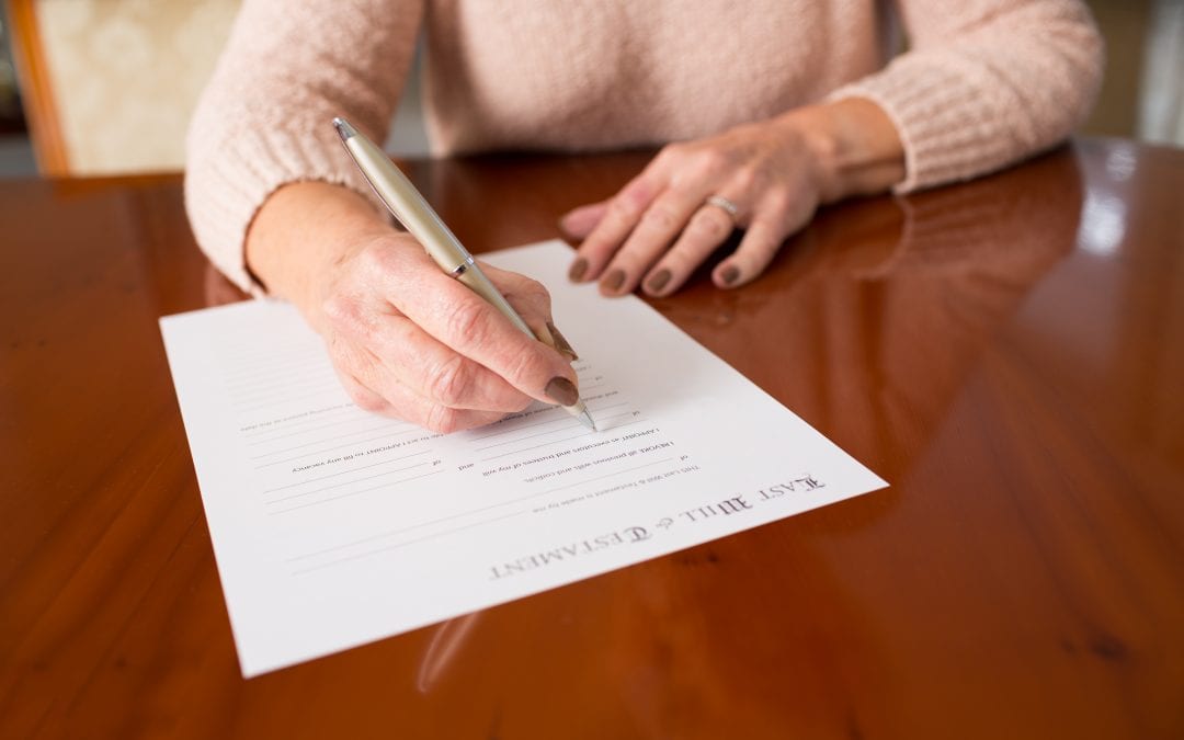 Senior Woman Signing Last Will And Testament At Home