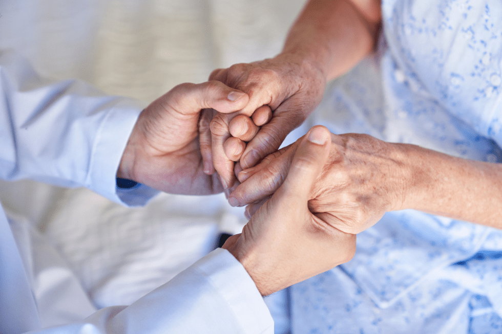 Older person holding younger person's hand